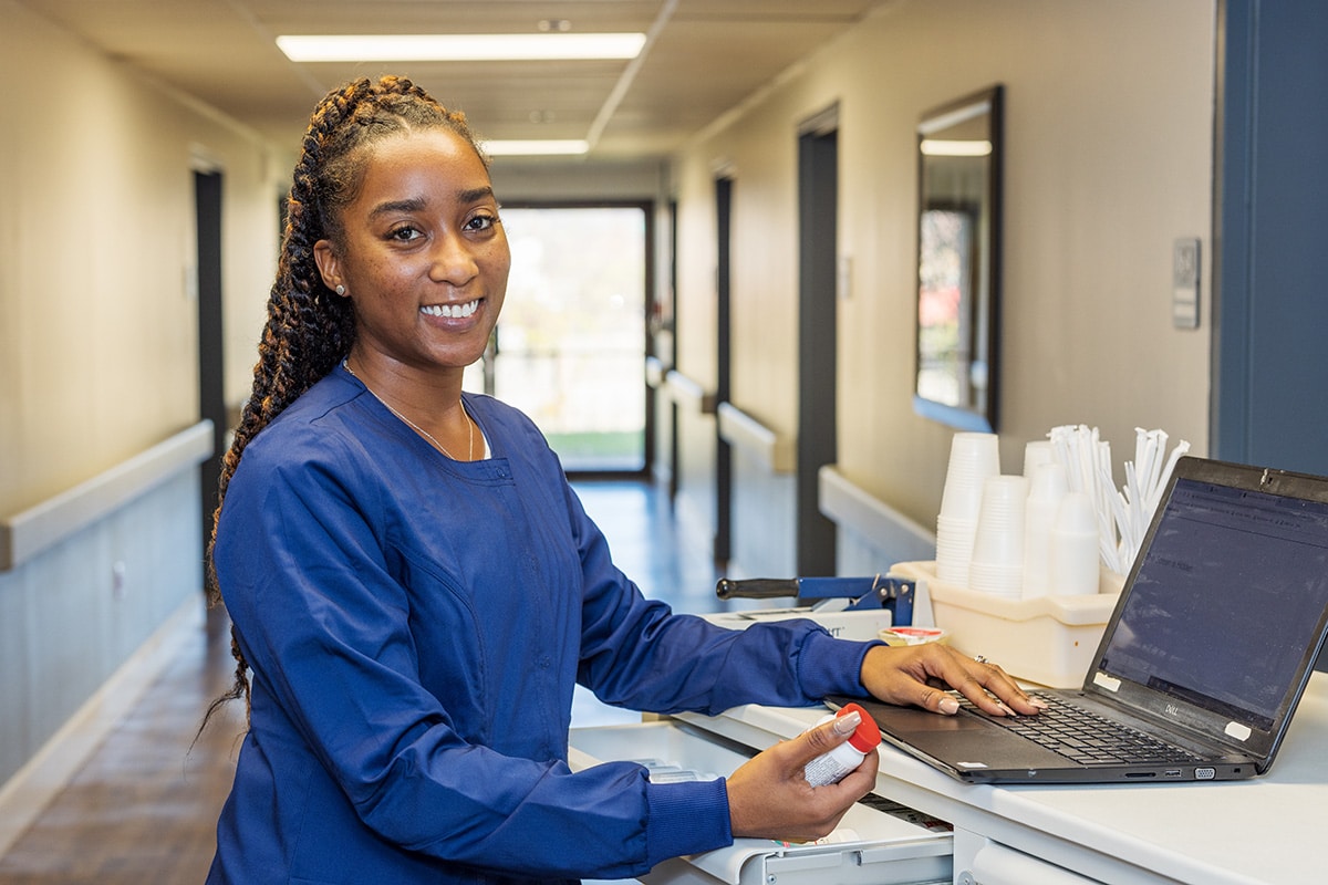 Nurse at a Nurse's cart in the hallway at Norwood Towers