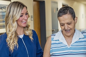 Nurse helping a resident in the hallway at Norwood Towers