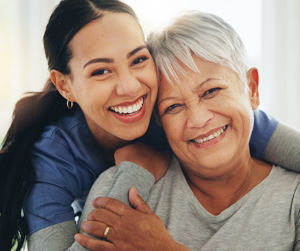 Happy woman, nurse and hug senior patient in elderly care, support or trust at old age home. Portrait of mature female person, doctor or medical caregiver hugging with smile for embrace at house